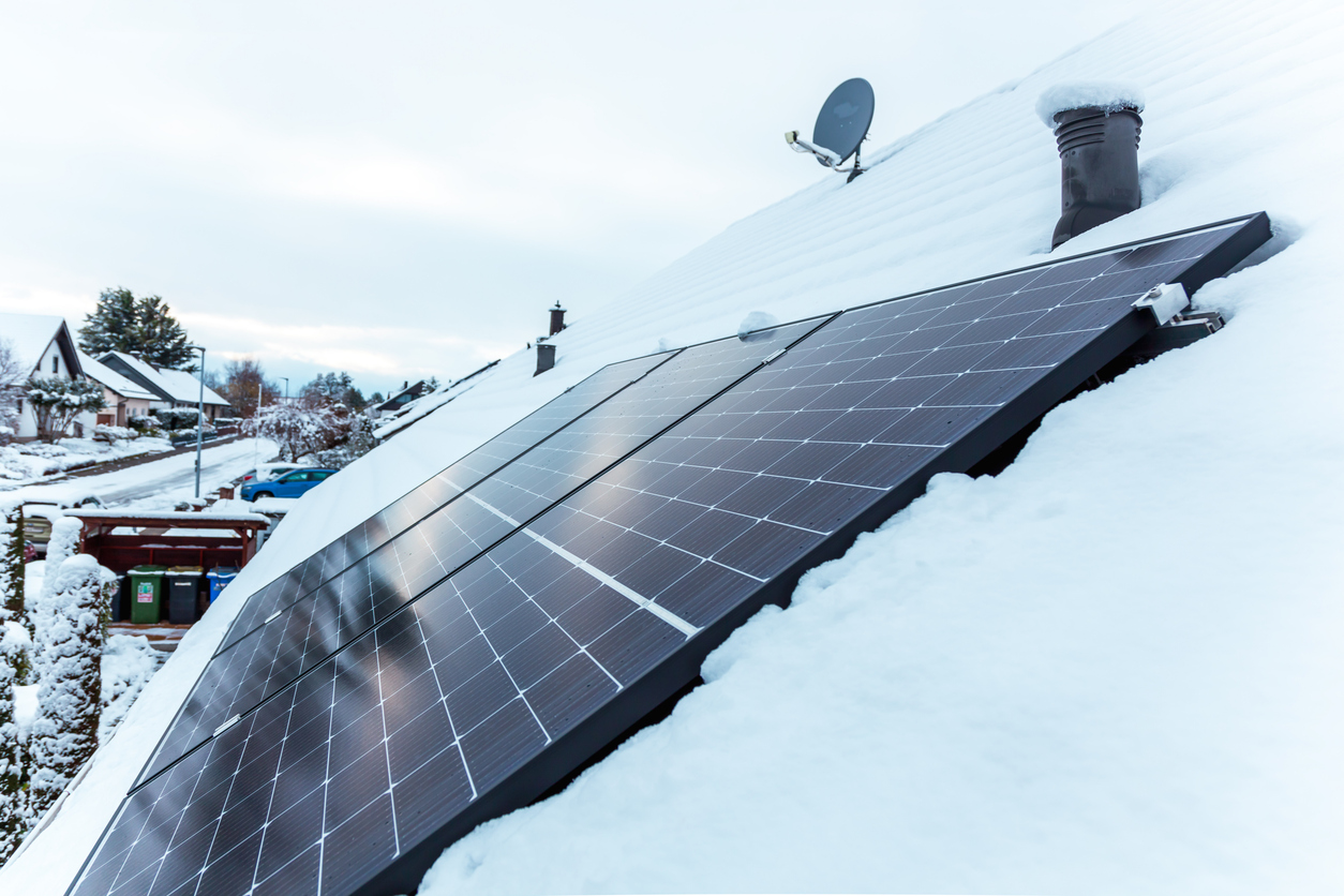 panel at rooftop with snow. removing snow off solar panels in winter. Removing snow photovoltaic system - solar cells. snow covers panels - no producing power. energy efficiency